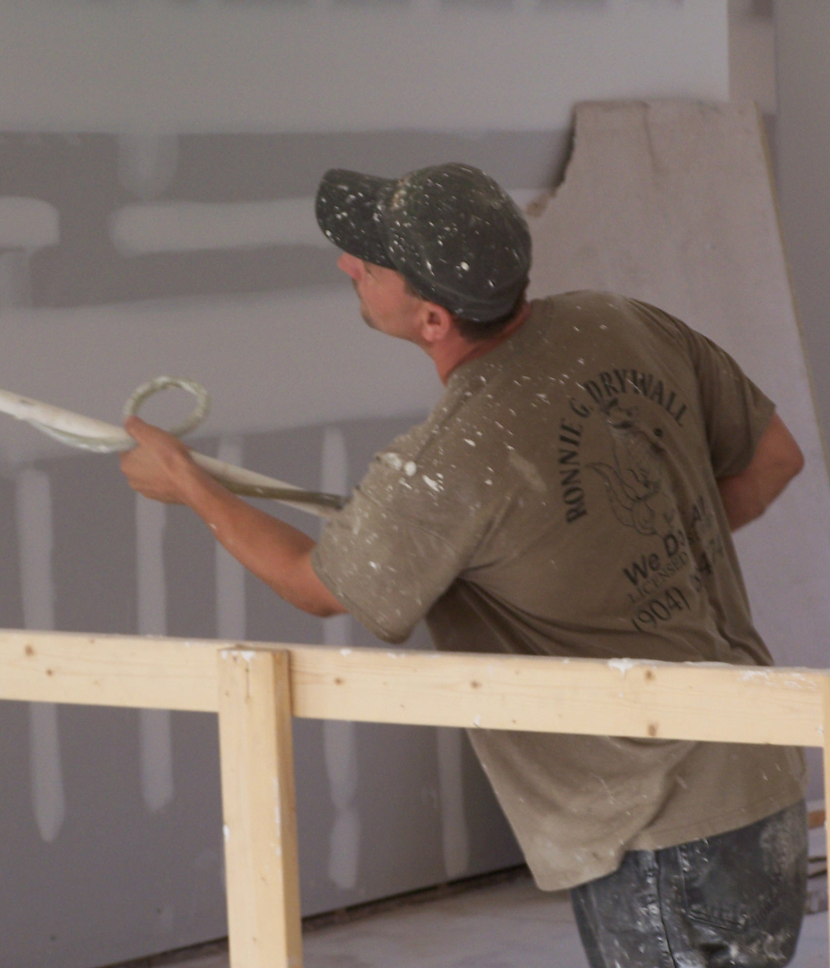 Worker plastering drywall surface